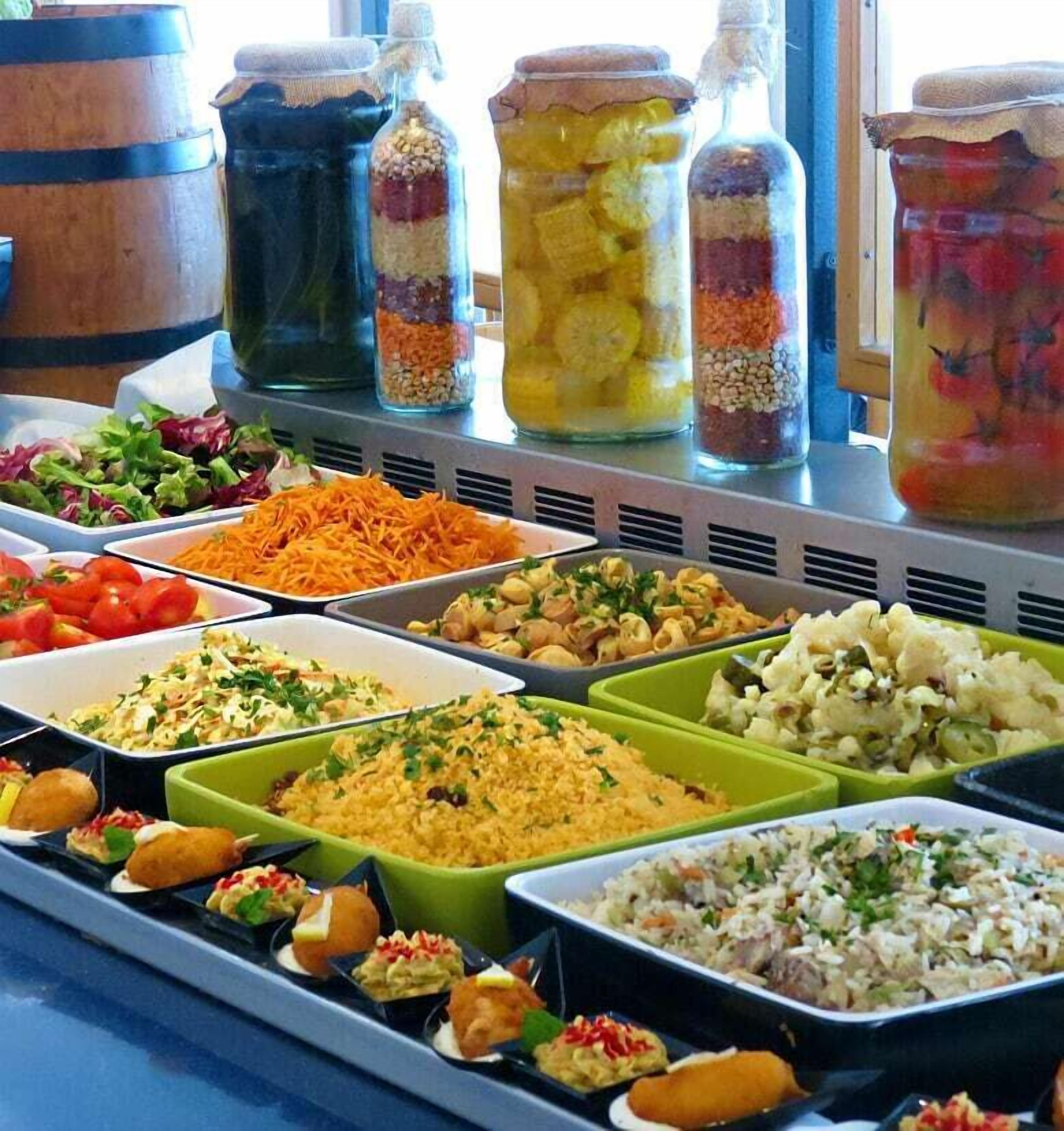 A buffet with various dishes and condiments.