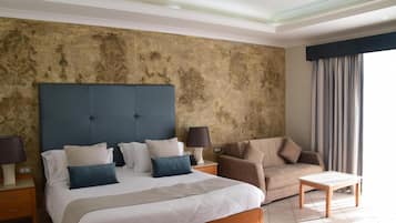 Une chambre d’hôtel avec un grand lit, un canapé, une petite table et une table de chevet.
