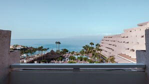 A resort with a pool, palm trees, and a view of the ocean. - Landmar Playa La Arena (Santiago del Teide)