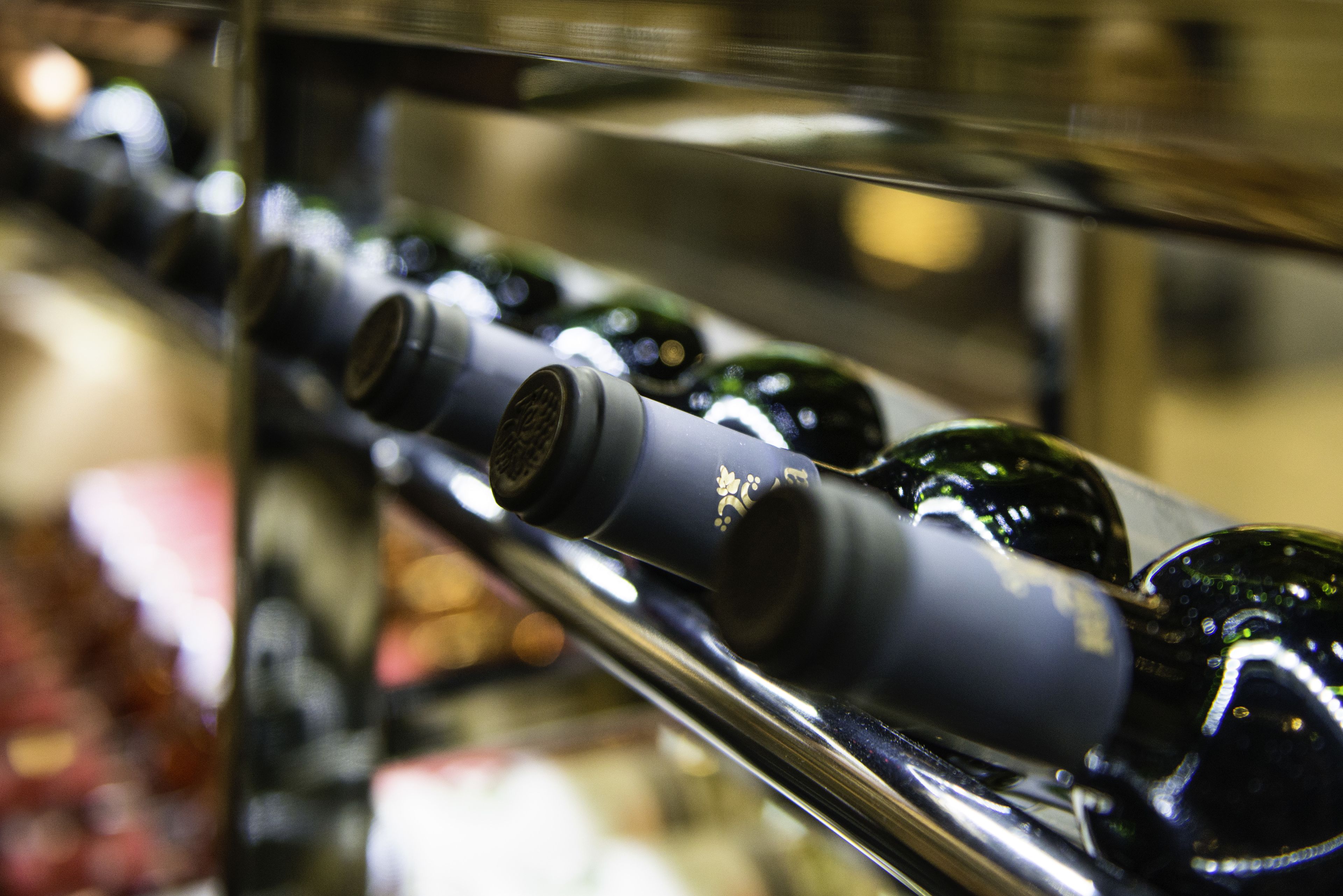 Una fila di bottiglie di vino su uno scaffale.