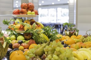 A fruit display with various types of fruits including apples, oranges, and grapes.