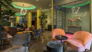 A modern lobby with round tables, comfortable seating, and decorative lighting. - Leonardo Hotel Antwerp (Antwerp)