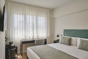 Relax in a stylishly designed room with a comfortable bed, desk, and large window.