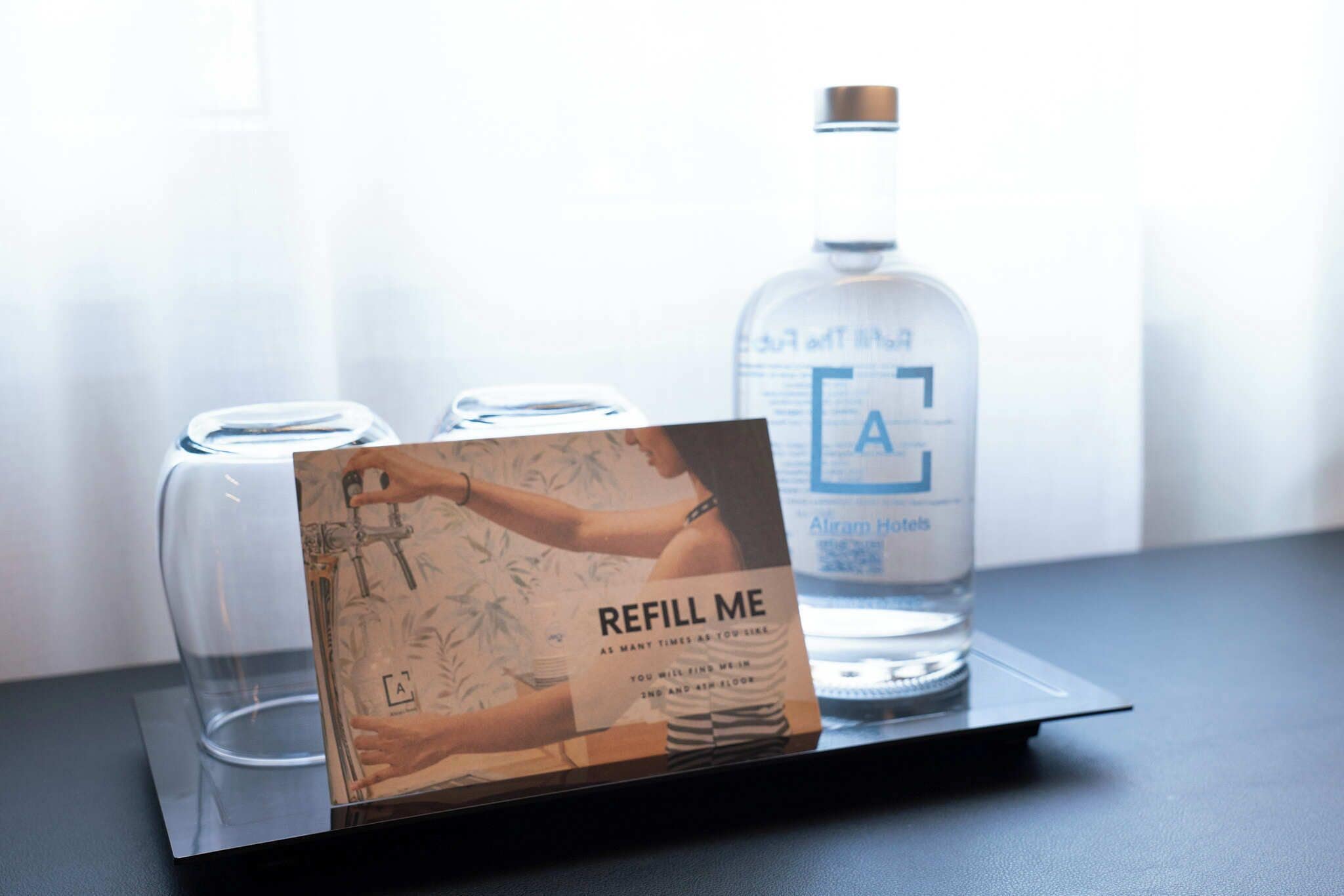 Une bouteille en verre, une carte et un verre sur un plateau.