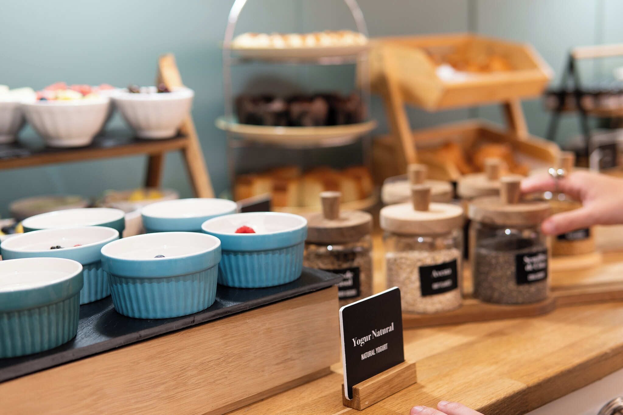 A display of natural yogurt in blue containers with a sign indicating 'Yogurt Natural'.