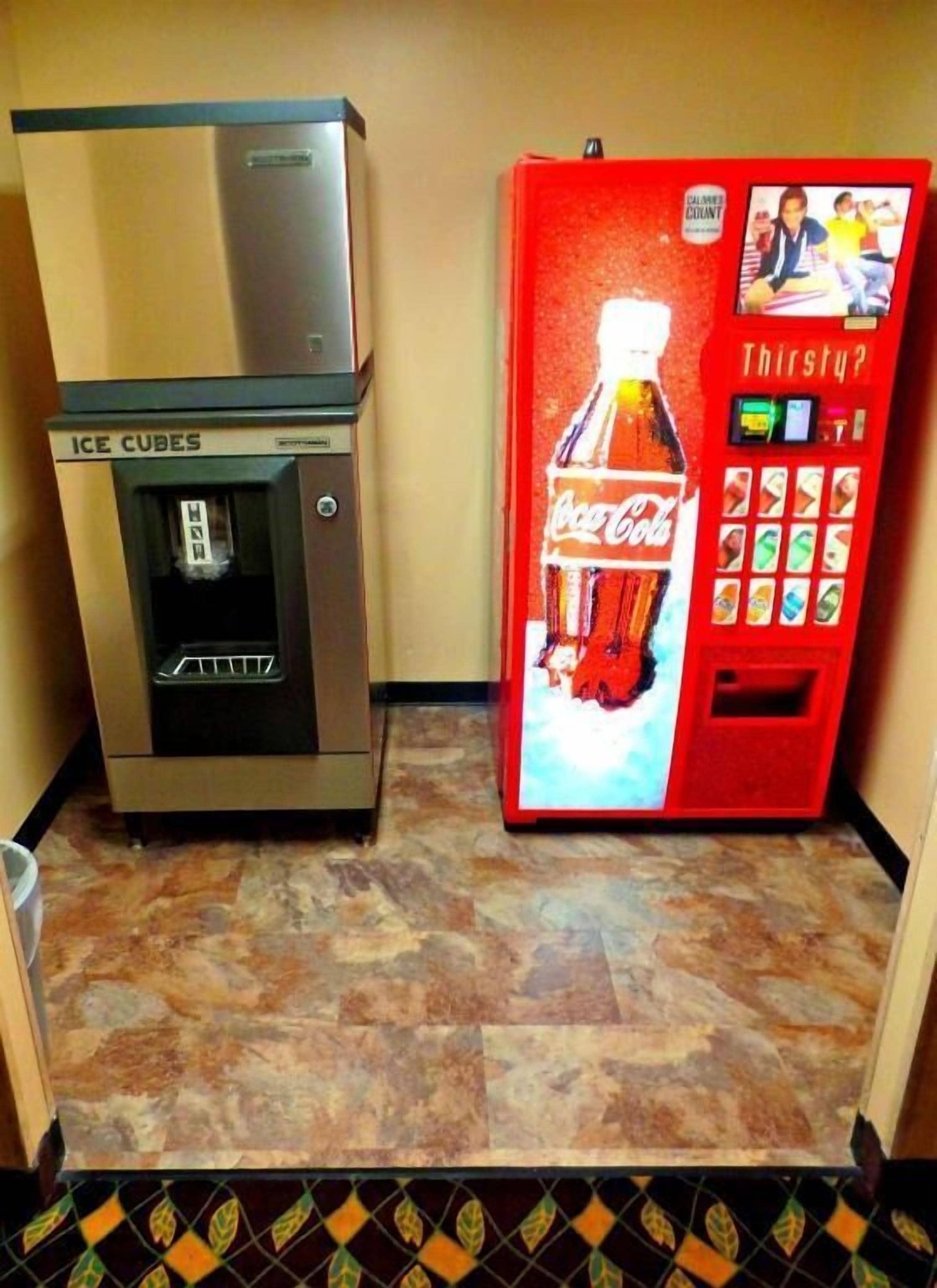 Un distributeur automatique orné du logo Coca-Cola et une machine à glaçons.