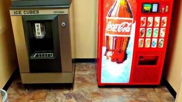 A vending machine with a Coca-Cola logo and a machine for making ice cubes.