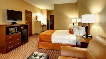 Ein Hotelzimmer mit Bett, Schreibtisch, Fernseher, Mikrowelle und einer Sitzecke.