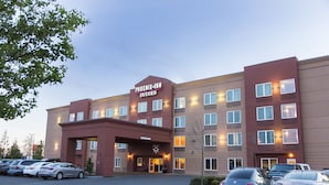 Un hôtel Phoenix Inn Suites doté de plusieurs étages, d’un parking et d’une entrée bien éclairée.
