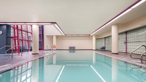 A swimming pool with clear water, surrounded by tiled walls and a ceiling with purple lighting. - Embarc Vancouver (Vancouver)