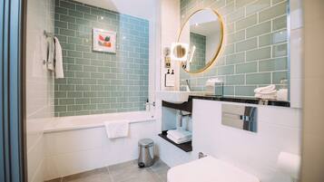 A modern bathroom with a bathtub, toilet, and sink.