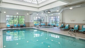 Una piscina con sillas de descanso y un tragaluz.