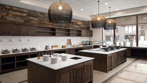 Una cocina moderna con dos islas, armarios de madera y un revoque de ladrillo.