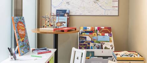 A children's play area with a map of Paris, educational toys, and a white chair.