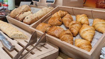 A bakery display with various breads and pastries.
