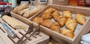 A bakery display with various breads and pastries.