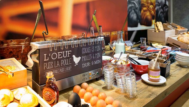 A breakfast buffet with various food items and a sign indicating the time for each item. - ibis Rodez Centre Cathédrale (Rodez)