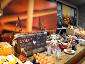 A breakfast buffet with various food items and a sign indicating the time for each item.