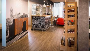 A modern bar area with a bar counter, seating, and a wine rack. - ibis Rodez Centre Cathédrale (Rodez)