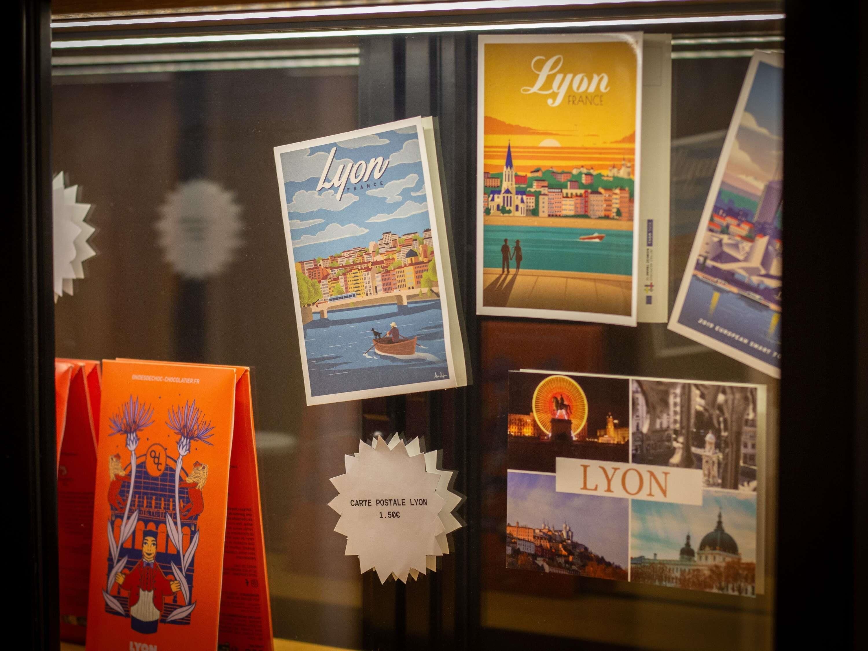 A display of postcards and a brochure with the word 'Lyon' and images of Lyon.