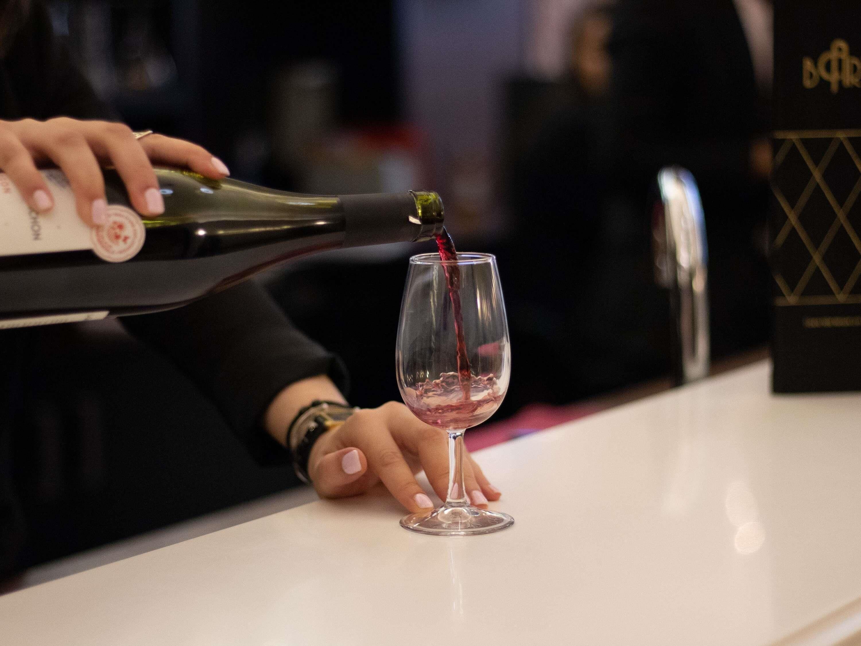 Una persona versa del vino in un bicchiere.
