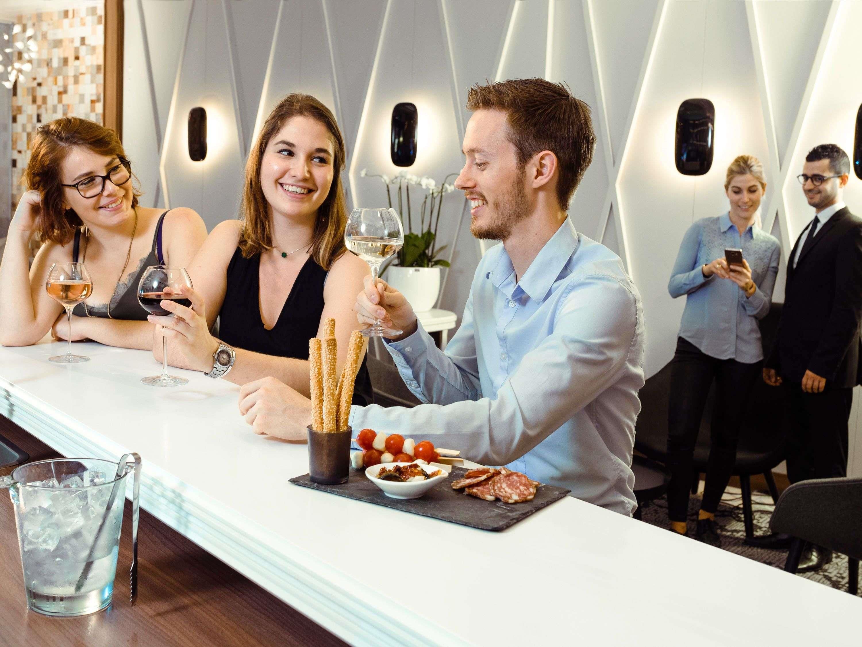 A modern interior with a bar area, seating, and a decorative wall.