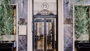 The entrance to a hotel with a marble facade, a number '73' above the door, and signs indicating 'Grand Hotel Des Deaux Arts'. - Mercure Lyon Centre Beaux Arts (Lyon)