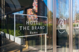 A hotel sign with a four-star rating and the name "The Brand" in Rome.