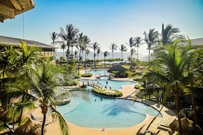A resort pool area with palm trees, a bridge, and a view of the ocean. - Fiesta Resort Central Pacific - All Inclusive (El Roble)