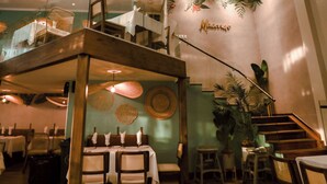 A dining area with tables, chairs, and a staircase.