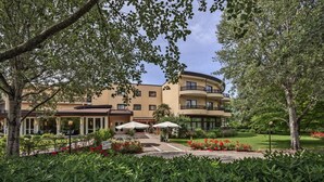 A hotel with a courtyard, outdoor seating, and lush greenery. - Park Hotel Junior (Quarto d'Altino)