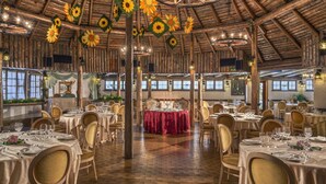 A spacious dining hall with multiple tables set for dining, wooden beams on the ceiling, and large windows allowing natural light. - Park Hotel Junior (Quarto d'Altino)