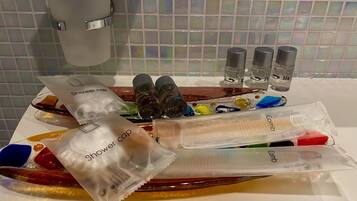 A bathroom counter with various toiletries including a shower cap, comb, and hair care products.