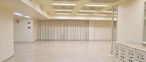 Una habitación amplia y luminosa, con techo alto, ventanas grandes y una distribución alargada.