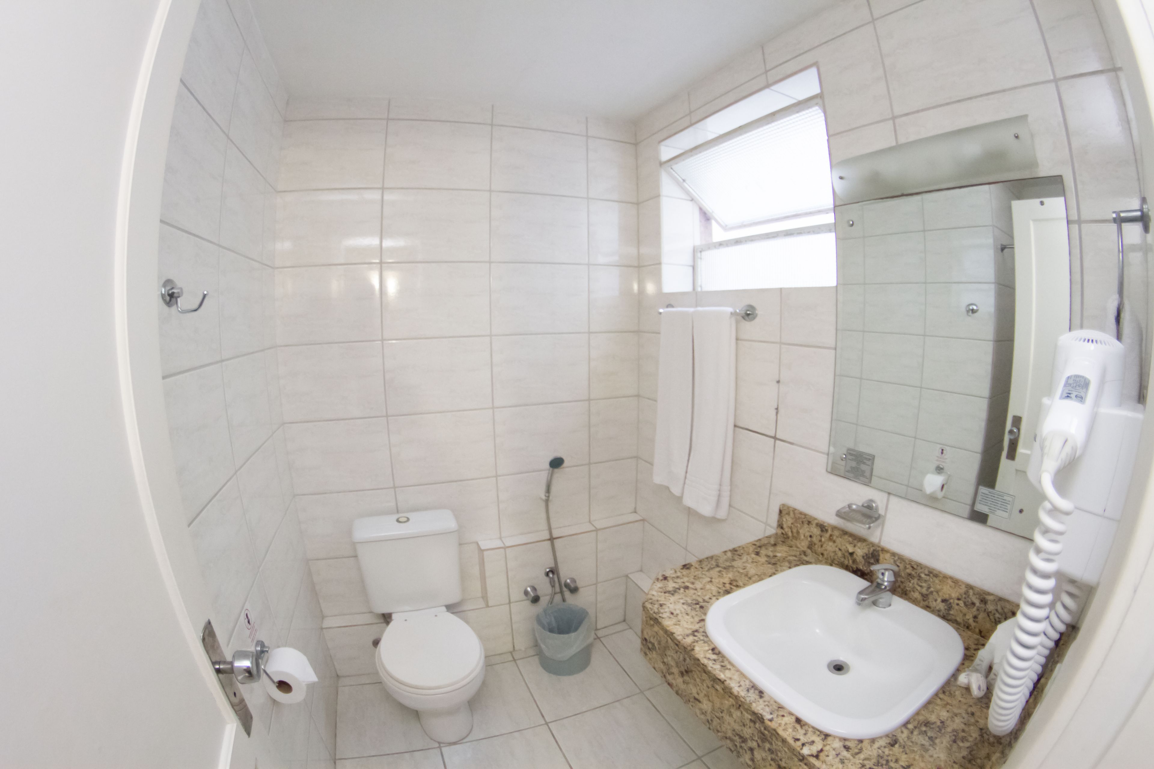A bathroom with a toilet, sink, and shower.