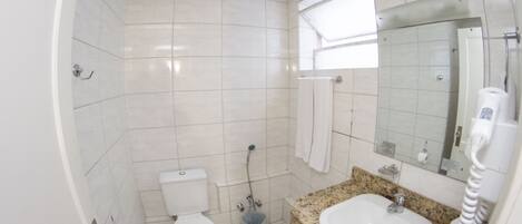 A bathroom with a toilet, sink, and shower.