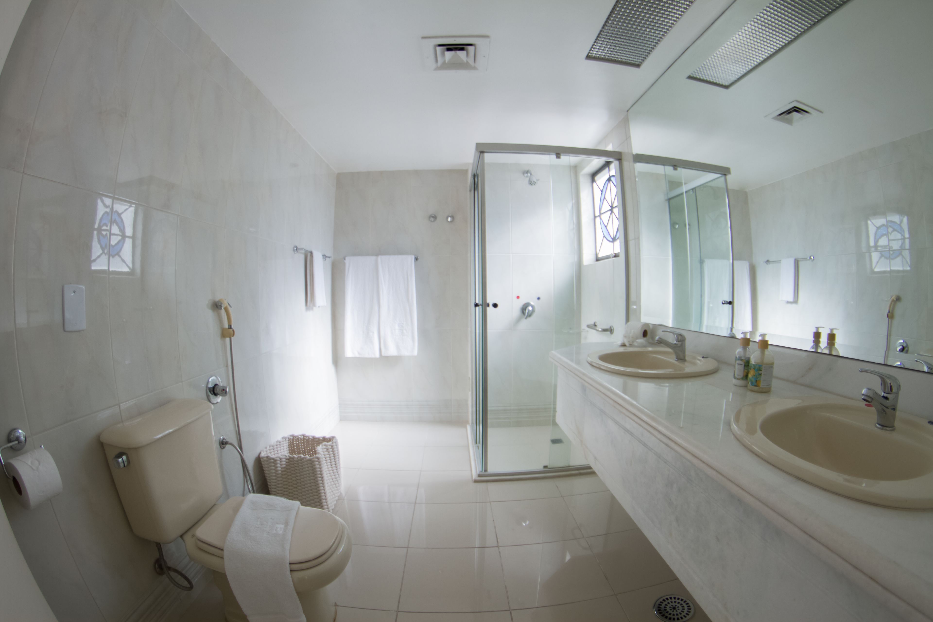 Un baño moderno con ducha acristalada, inodoro y tocador doble.