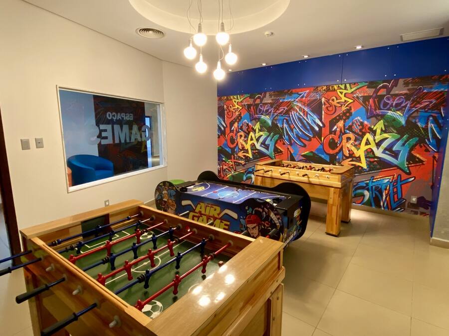 Ein Zimmer mit einer Fußballtischkicker-Anlage, einer Fußballtischkicker-Anlage mit farbigem Hintergrund und einer Wand mit Graffiti.