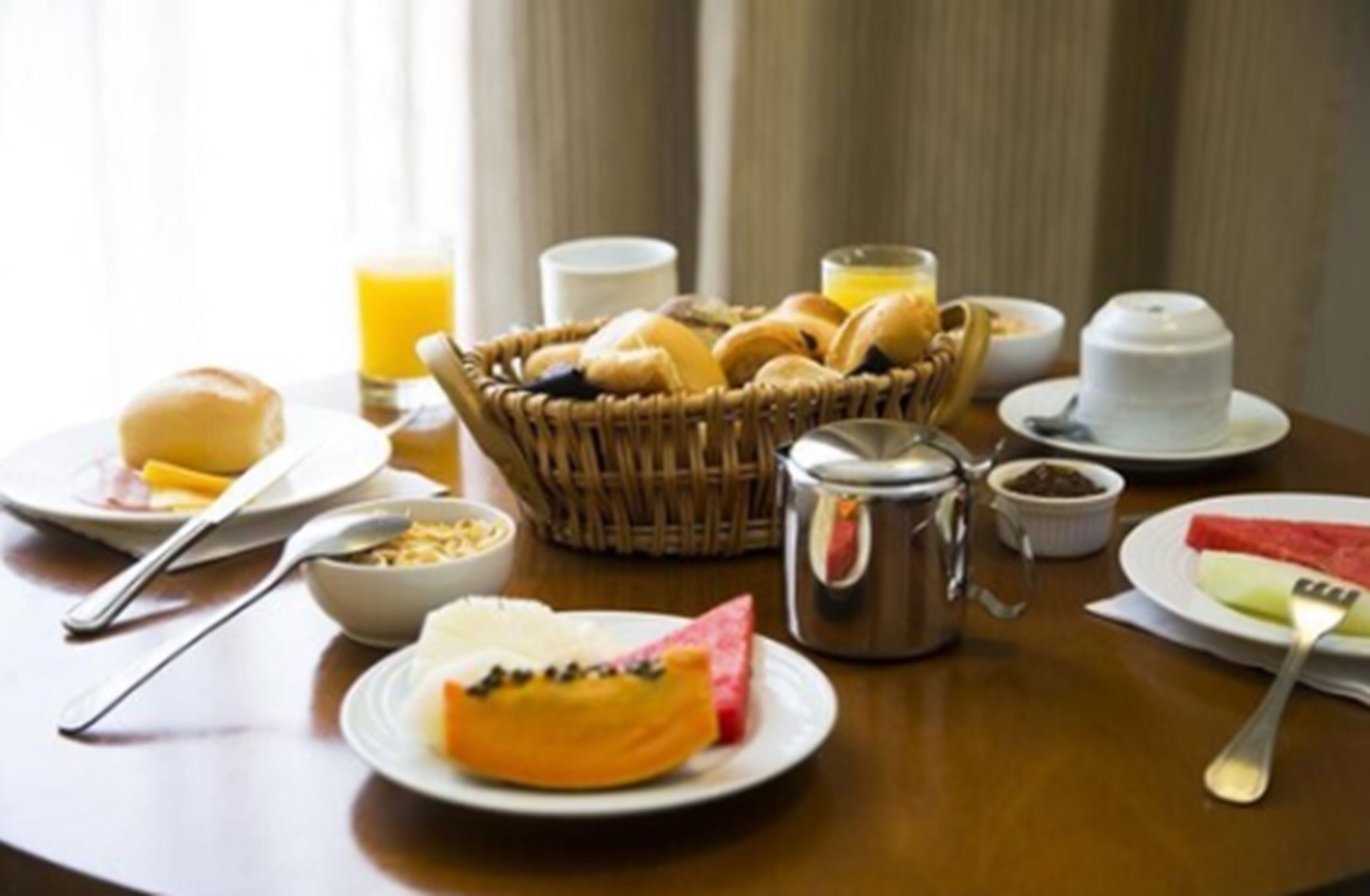 Una mesa de desayuno con diversas opciones de comida, como pasteles, fruta y bebidas.