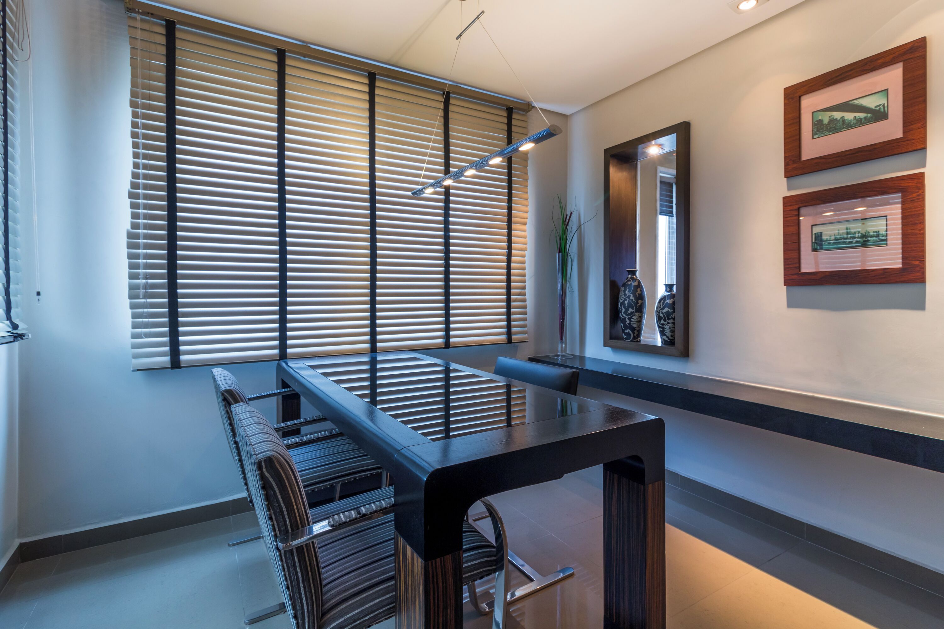 Un comedor moderno con una mesa larga, sillas y una lámpara contemporánea.