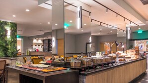 A buffet setup with various food items and cooking stations. - Parque Balneário Hotel Santos by Castelo Itaipava (Santos)