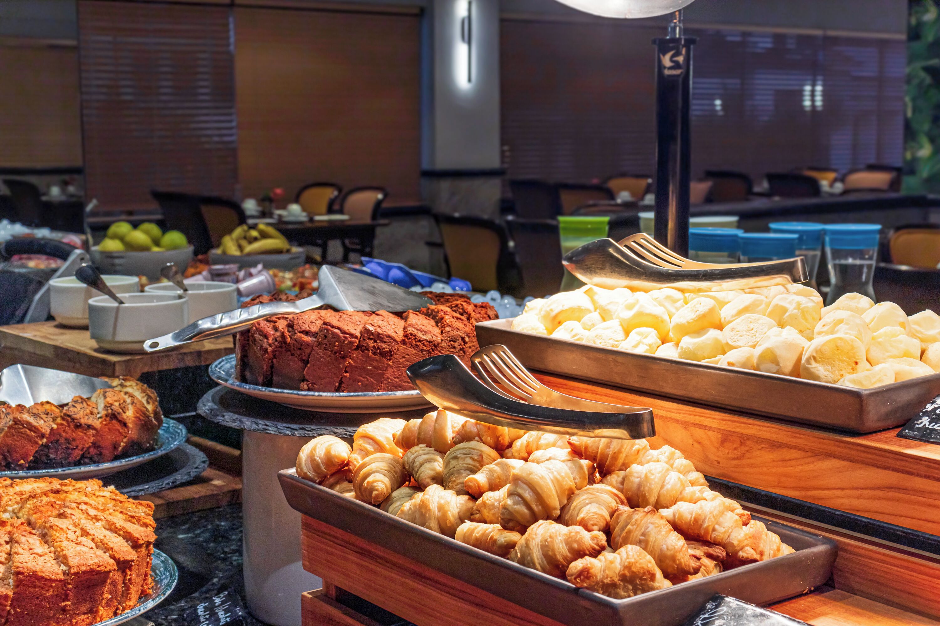 Un bufé con diversos alimentos, incluyendo pasteles, frutas y un pastel.