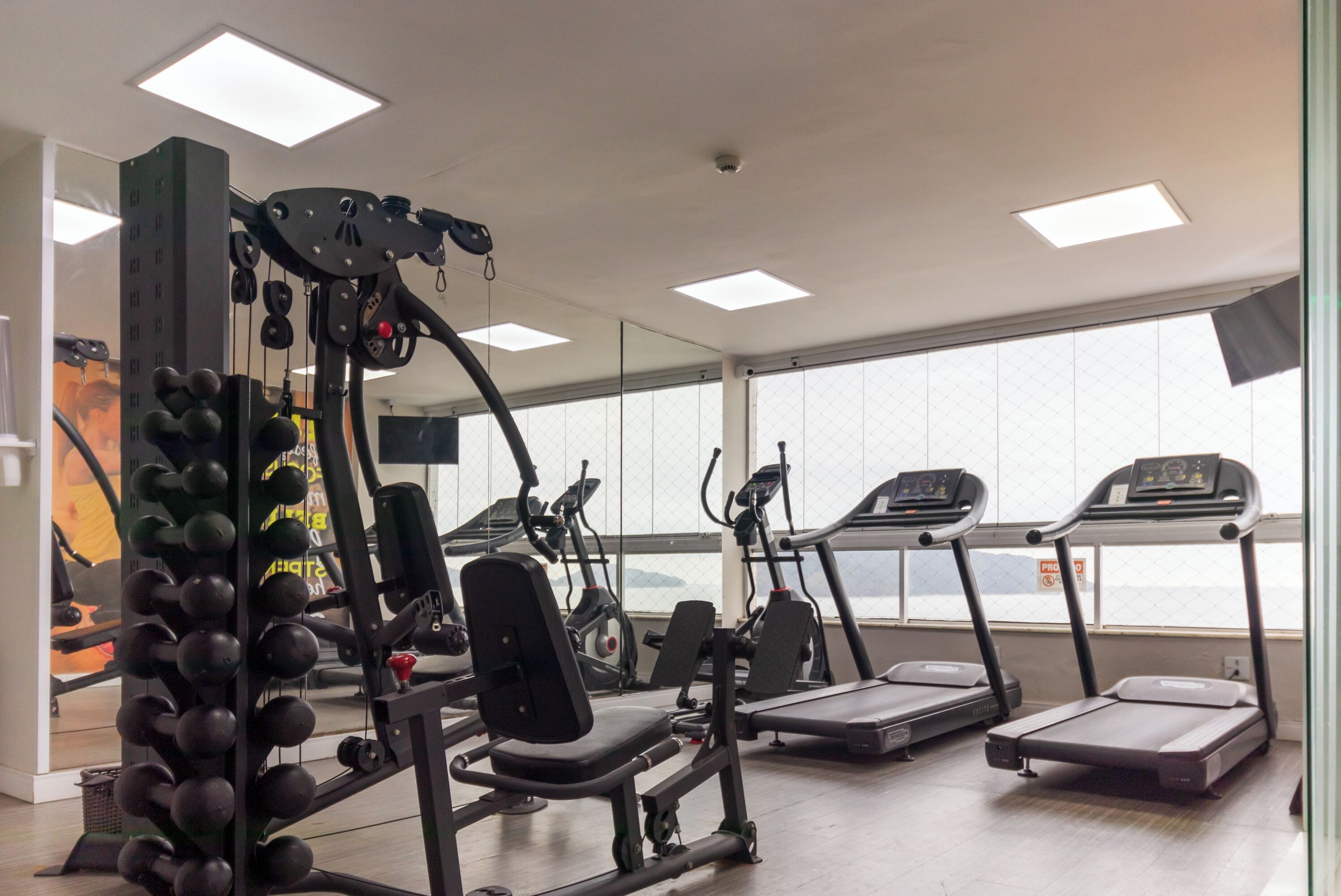 Une salle de sport équipée de tapis de course, d’appareils de musculation et d’un rameur.