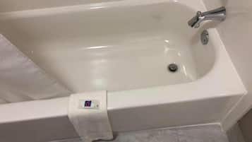 A white bathtub with a single faucet and a drain.