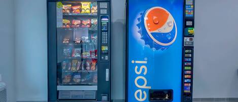 Two vending machines, one with a Pepsi logo and the other with various snacks.