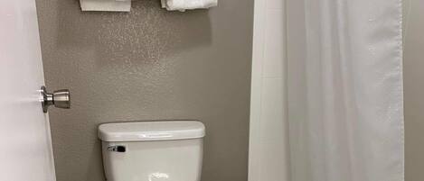 Ein Badezimmer mit Toilette, Mülleimer und Badewanne.