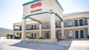 Um hotel com uma placa de destaque 'OYO INN & SUITES', apresentando uma construção de dois andares com varandas e uma entrada coberta.