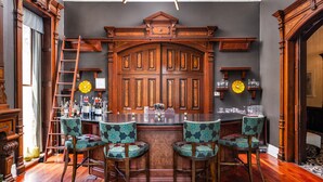A bar area with wooden furniture, a large wooden cabinet, and a clock on the wall.
