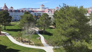 A resort with a central building featuring multiple red-roofed towers, surrounded by well-maintained lawns and pathways.