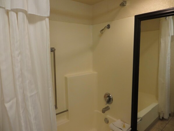 A bathroom with a shower, a toilet, and a bathtub.